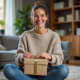 Femme souriante déballant un cadeau de Noël dans un salon chaleureux